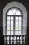 A fragment of a high semicircular arched window with a frame in a dark interior.