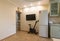 A fragment of the interior of the living room combined with the kitchen, a TV hangs on the wall, an exercise bike and a