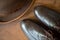 Fragment of men’s brown boots blind brogues and bowler hat on a wooden background. Vintage men’s English style.