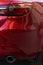 Fragment of a modern red car, rear headlight and bumper