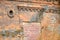 Fragment of an old red brick wall. Bricked window opening with decoration and lined round opening.