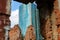 Fragment of an old ruined brick building against the background of a fragment of the glass facade of an office building