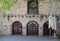 A fragment of an old stone building with a patterned wall and beautiful arched windows at floor level