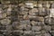 Fragment of old stone wall made of different form and size rocks.