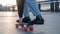 Fragment of a penny board and legs close-up.