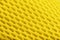 Fragment of a perforated toe of a yellow sneaker in close-up