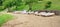 Fragment of the public sandy beach with white wooden chaise lounges.