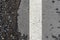 Fragment of road markings at the curb. Fragment of a white stripe on asphalt. Abstract background