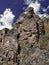 Fragment of a rock against a blue sky with clouds in clear sunny