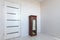 A fragment of a small bedroom in an apartment with poor furniture, a view of the front door and a locker