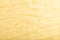 Fragment of smooth yellow linen tissue. Top view, natural textile background