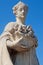 Fragment of a statue of Flora in the blue sky.