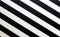 Fragment of a striped black and white piece of a plastic as a background texture