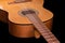 Fragment of traditional acoustic guitar on black background, selective focus