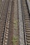 Fragment of two parallel railroad tracks lying on on railway ballast bed made of gravel. Top view from the bridge