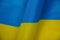 Fragment of the Ukrainian flag. The surface of the wavy blue-yellow fabric. Top view, flat lay. Satin surface. Independence