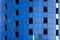 Fragment of an unfinished building under construction with blue cladding panels