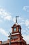 Fragment of the upper part of the historical building with a tower demonstrates the beauty of brick sacred architecture. A large