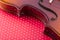 Fragment of violin on a red background, close-up