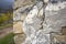 Fragment of the wall of an old dilapidated stone house. Cracked and in some places collapsed plaster