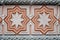 A fragment of a wall trimmed with carved multi-colored tiles with eight-pointed stars