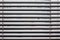 Fragment of the white Venetian blinds with lift cord and turning rod of a manual control on a foreground .