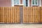 Fragment of a wooden brown modern fence with brick columns, close-up. Modern design ideas of a wooden fence
