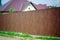 Fragment of a wooden brown modern fence, close-up. Modern Style Design wooden Fence Ideas