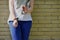 Fragment of a young criminal girl`s body with hands in handcuffs against a yellow brick wall