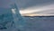 Fragments of ice are scattered over the surface of the frozen lake.