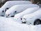 Fragments of parked cars covered with snow