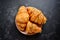 Fragrant croissants on a dark table isolated background. Delicious sweet pastries for breakfast