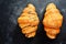 Fragrant croissants on a dark table isolated background. Delicious sweet pastries for breakfast