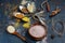 Fragrant cuisine. Colored spices in spoons, wooden bowl, cinnamon sticks and senena sesame and flax on a dark blue old background