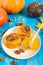 Fragrant golden pumpkin pancakes with honey and walnuts on a blue wooden background.