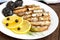 Fragrant Golden smoked small fish capelin `Sprat` on a white plate on a dark wooden background