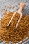 Fragrant grains of fenugreek on a rustic background