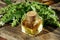 Fragrant oil with basil close-up in a bottle on a wooden