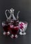 Fragrant red rose syrup sherbet in stylish glass pitcher on black with ice cubes