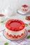 Fraisier mousse cake. Strawberry cake with biscuit, mousse and jelly on a white wooden background. Summer dessert. Selective focus