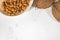 Frame of almond nut seeds in plate and coconuts, white background with selective focus, free space for text, top view