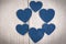 Frame of blue hearts on a light wooden background.