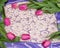 A frame of delicate pink tulips, lilac fabric and a background
