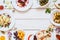 Frame of delicious snacks on white table flat lay
