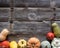 Frame of different pumpkins and squashes over wood, copy space