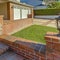 Frame Facade of a house with a patio and outdoor stairs paved with rustic red bricks