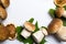 Frame of freshly picked forest mushrooms on white background, top view. Compositiof dry maple leafs, ceps, and dry orange slices A