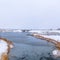 Frame Frosty nature secnery with a lake surrounded by snowy terrain in winter