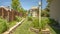 Frame Garden with lush plants and childrens playground under blue sky on a sunny day