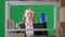 In a frame on a green background of chromakey. There is a young woman in a suit. The manager is shown in a warehouse